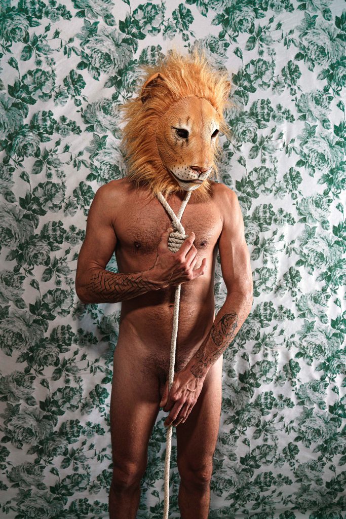 Animalización, león con una soga de corbata es un proyecto artístico de editorial de moda para NFT- © Rosa Teixidor